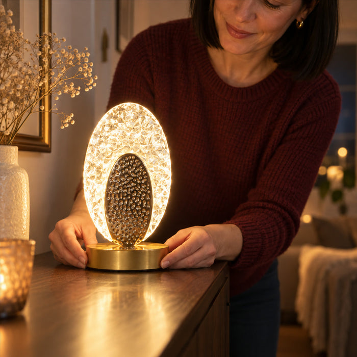 Tischlampe mit ovalem Leuchtrahmen in Kristalloptik und gehämmertem Mittelteil für Nachttisch und Kommode – runder Fuß in Gold, warmweißes Licht